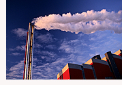 image of a large smoking chimney against a blue sky